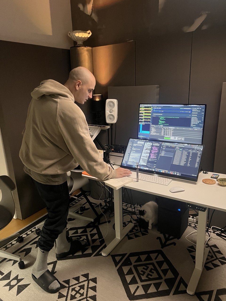 Founder standing at a desk writing code at night